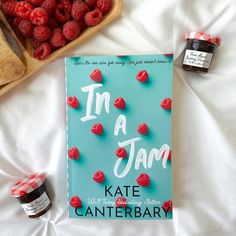 the book in a jam by kate canterbar sits on a bed next to raspberries