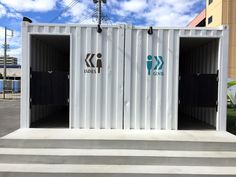 two white shipping containers sitting on top of cement steps