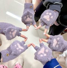 several people are holding their hands together in the shape of a circle with pink and purple designs on them