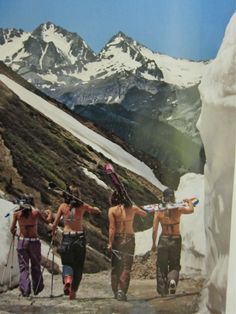 three men with skis and snowboards walking up a mountain