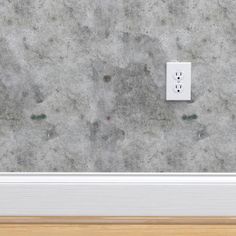 an electrical outlet on the wall in a room with wood flooring and concrete walls