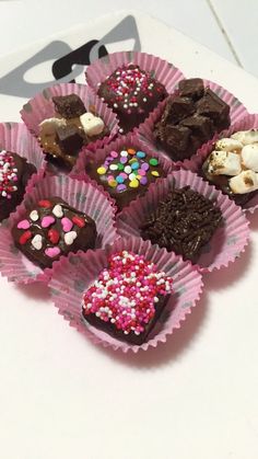 there are many different types of chocolates in the cupcake liners on the table