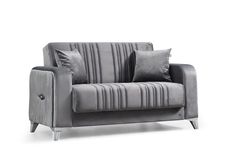 a gray couch with two pillows on it and some silver furniture in front of white background