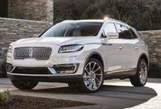 a white lincoln suv parked in front of a building