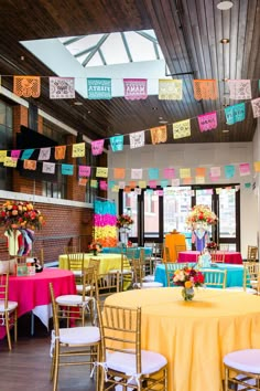 a room filled with tables and chairs covered in yellow cloths