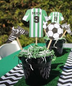 a table topped with cupcakes and cake toppers next to a potted plant