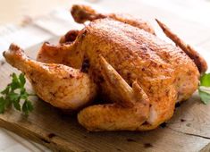 a roasted chicken on a cutting board with parsley