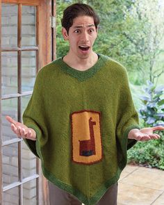 a man wearing a green knitted sweater has his hands out in front of him