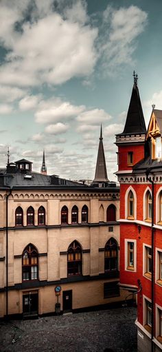 an old building with many windows and towers on it's sides, against a cloudy sky