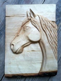 a wood carving of a horse's head on a piece of wooden planks