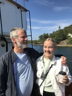 a man and woman are standing on a boat