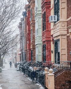 the snow is falling down on this city street