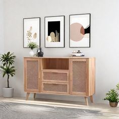 a living room with two pictures on the wall and a sideboard in front of it