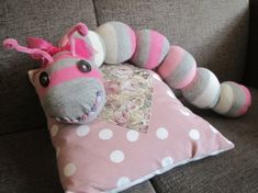 a stuffed animal is laying on top of a pink and white pillow with polka dots