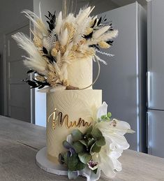 a three tiered cake decorated with feathers and flowers