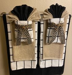 two black and white towels are hanging on a towel rack with burlocks tied around them