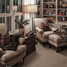 a living room filled with furniture and bookshelves next to a window covered in shutters