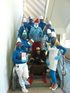 a group of people dressed in costumes posing on an escalator