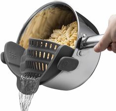 a person is holding a grater over a sink with food in it and water coming out