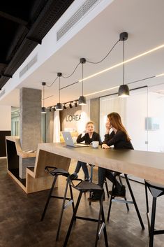 two women sitting at a table in an office