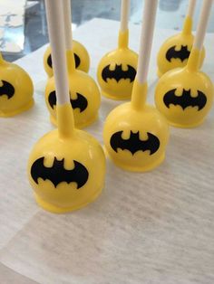 some yellow and black batman lollipops on a table