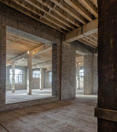 an empty room with exposed brick walls and wooden beams