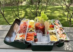 an assortment of food sitting on top of a picnic table