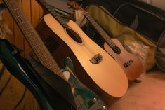 three guitars are lined up on the floor