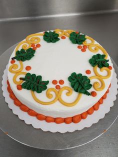 a white cake with orange and green decorations