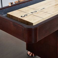 a wooden shuffle table with numbers on the top and side boards attached to each end