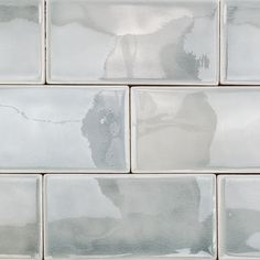 the reflection of a person in a mirror on a tile backsplashe wall