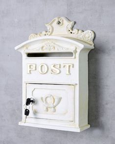 a white mailbox mounted to the side of a wall