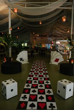 an indoor area decorated with black, white and red playing cards on top of dices