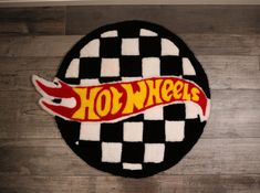 a black and white checkered rug with the word hot wheels on it