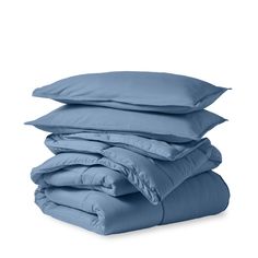 the blue sheets and pillows are stacked on top of each other in front of a white background