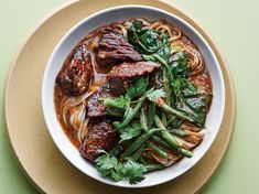 a bowl filled with meat and vegetables on top of a table