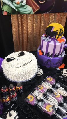 a table topped with cake and candy covered in frosting next to halloween decorations on top of it