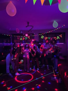 a group of people standing on top of a dance floor in front of neon lights