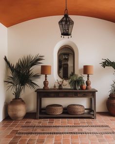 an entryway with potted plants and a mirror