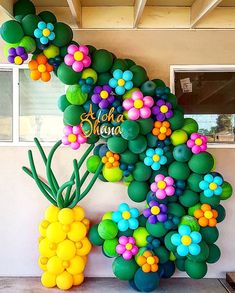 the balloon art is made to look like a tree and has flowers on it for decoration