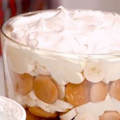 a glass bowl filled with fruit and whipped cream