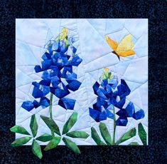 blue flowers and a yellow butterfly are featured in this quilt