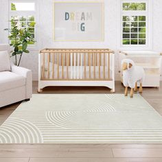 a baby's room with a white crib, chair and large rug on the floor