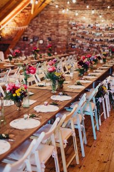 the tables are set with white chairs and floral centerpieces