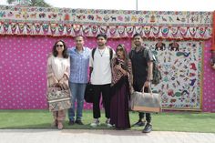 four people standing in front of a decorated wall