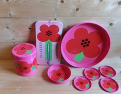 a pink flower themed tableware set with measuring tape and spoons on the side