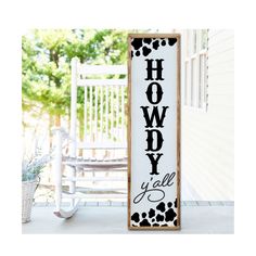 a wooden sign that says hollywood y'all with hearts on it next to a rocking chair