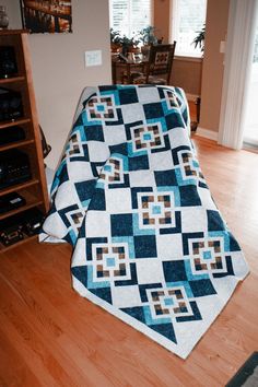 a blue and white quilt sitting on top of a wooden floor