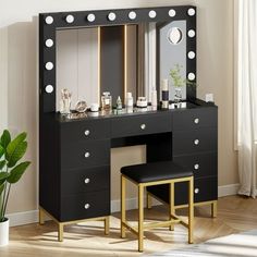 a black vanity with lights on it and a stool in front of the mirror that is next to it