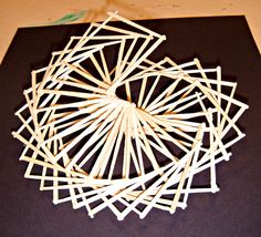 sticks are arranged in the shape of a circle on top of a black paper sheet